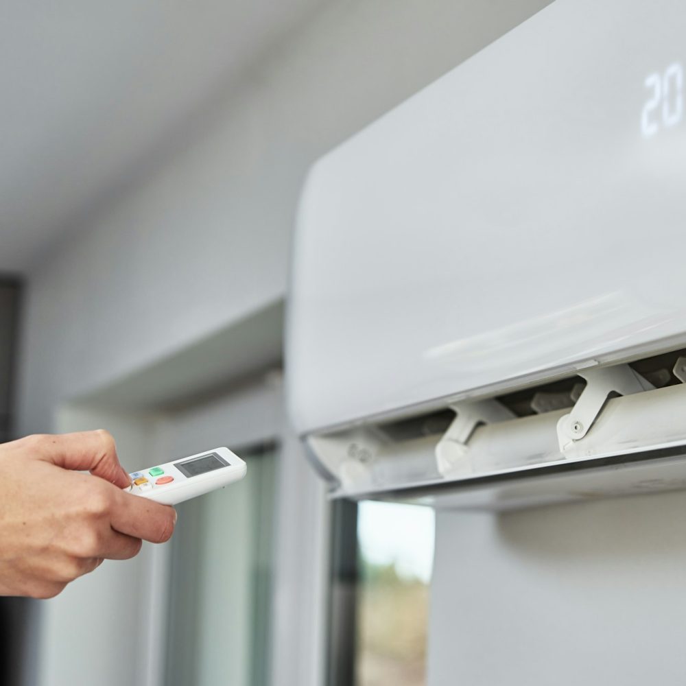 Hand adjusting temperature on air conditioner